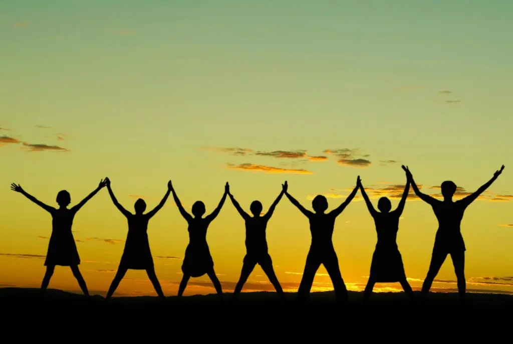 A group of people standing by holding each other hand