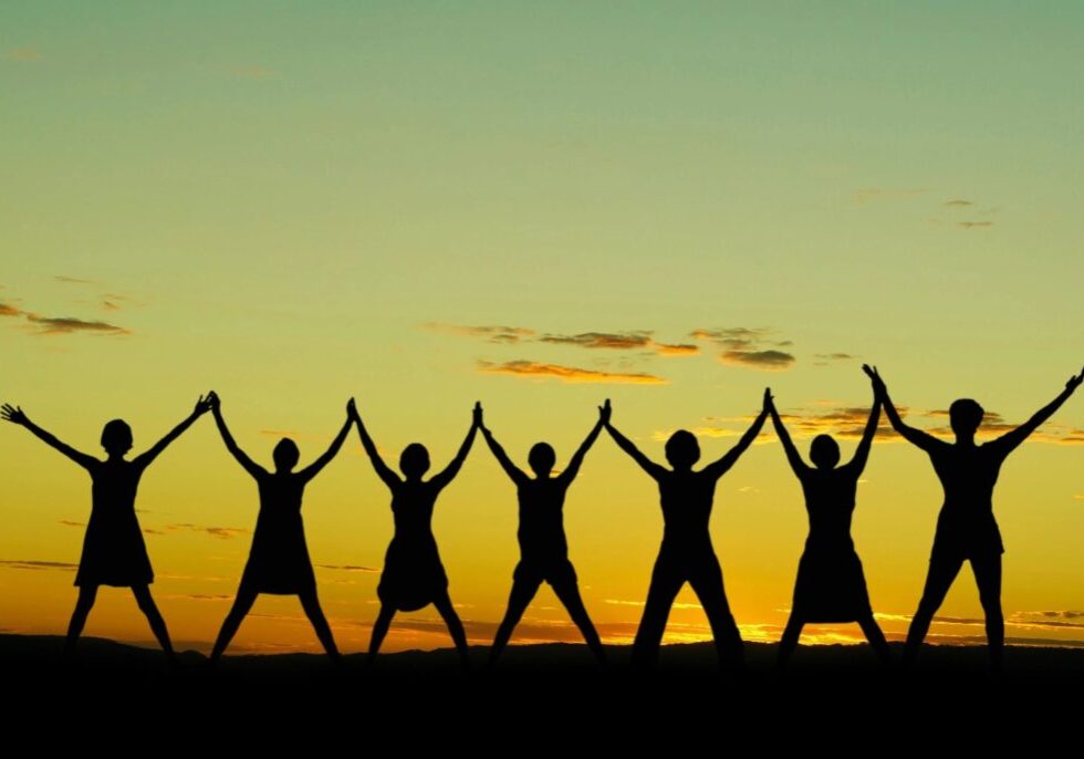 A group of people standing by holding each other hand